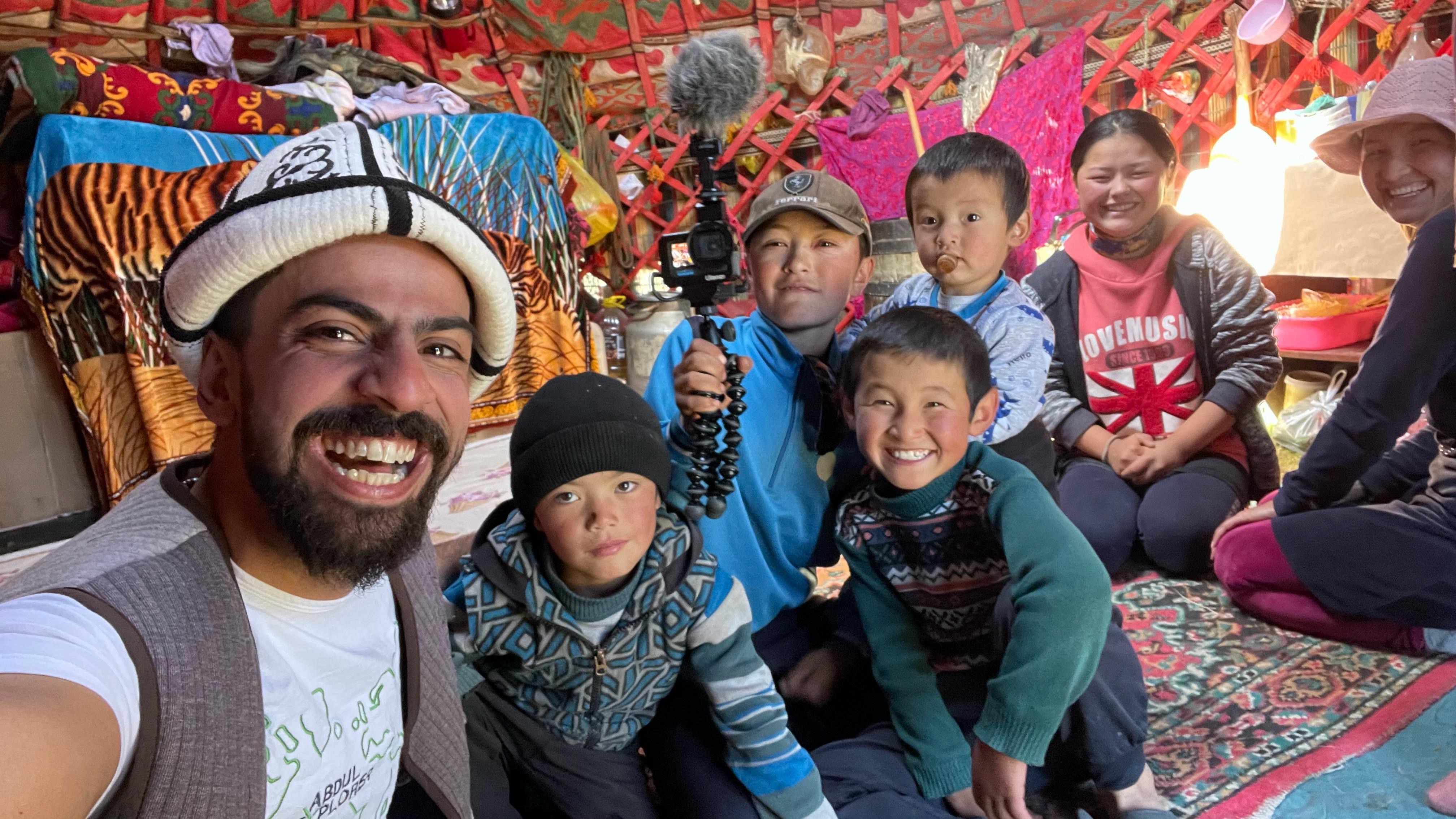 Abdul Explorer with local children in a yurt during a Central Asian expedition